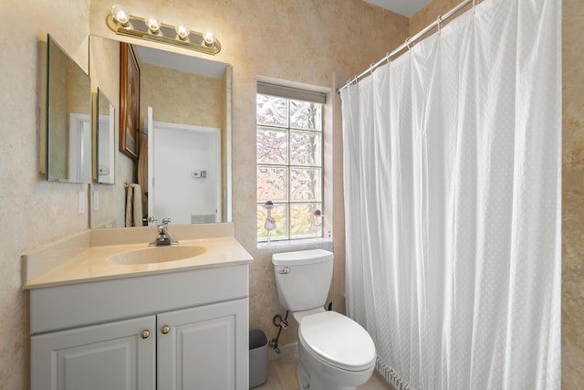 bathroom featuring plenty of natural light, toilet, vanity, and curtained shower