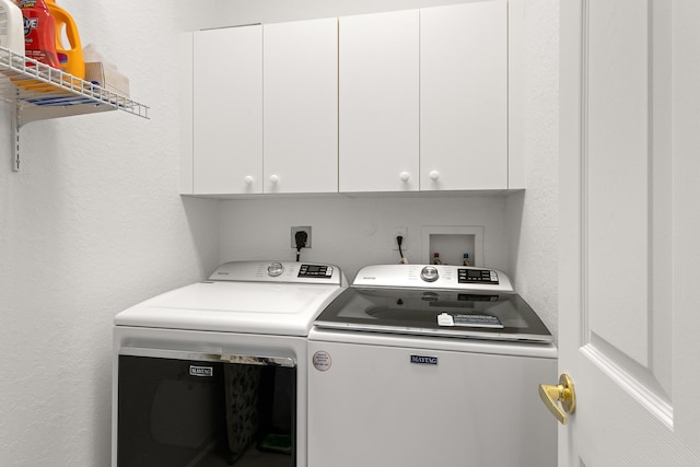 laundry area with independent washer and dryer and cabinet space