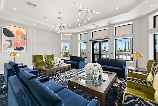 living room featuring a raised ceiling, ornamental molding, a chandelier, recessed lighting, and healthy amount of natural light