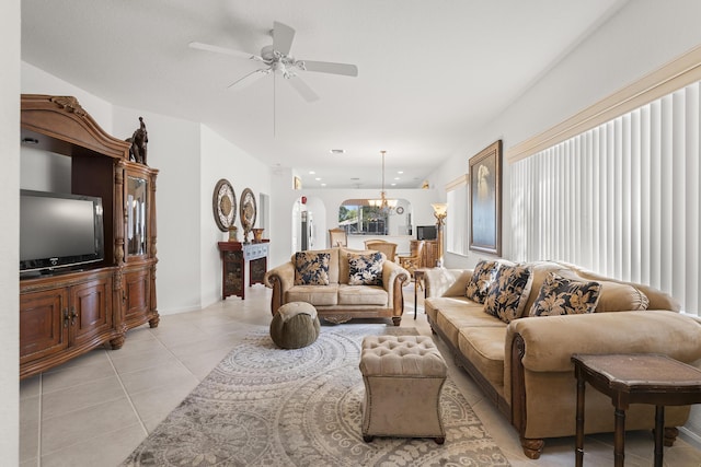 living area with light tile patterned flooring, ceiling fan, and arched walkways