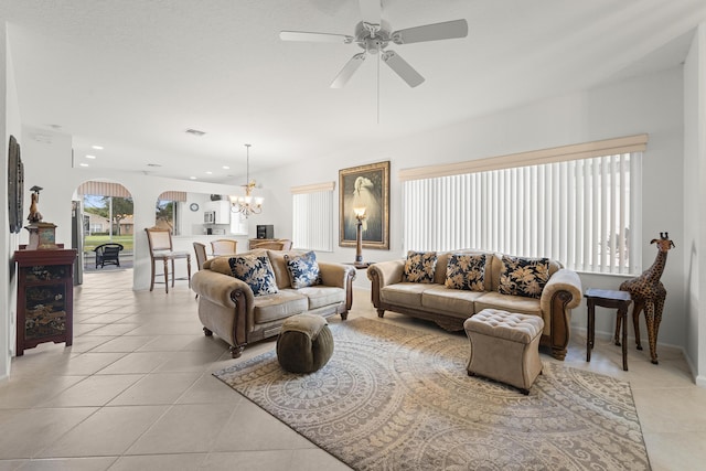 living area with light tile patterned floors, a chandelier, recessed lighting, a ceiling fan, and arched walkways