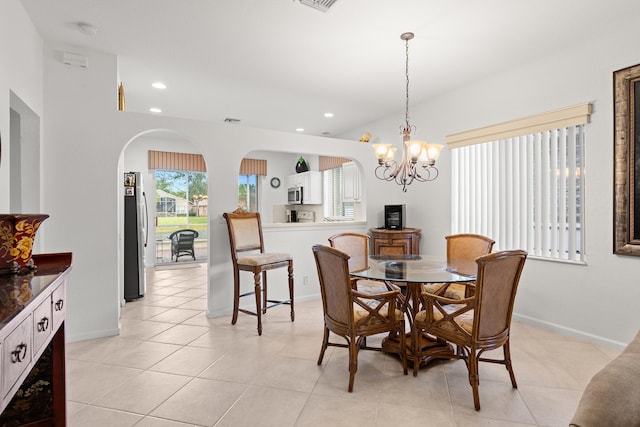 dining space with arched walkways, a chandelier, recessed lighting, baseboards, and light tile patterned flooring