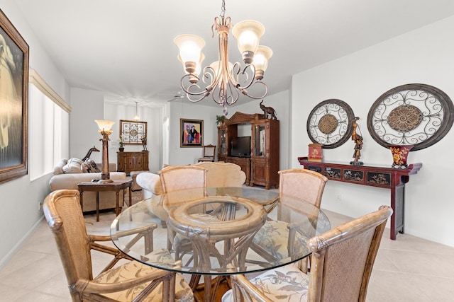 dining area featuring light tile patterned floors, a chandelier, and baseboards