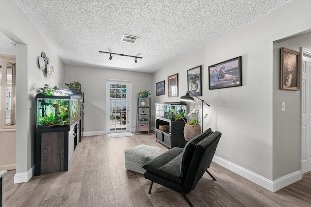 639 Mallard Dr, Delray Beach, FL 33444 - living area with light wood-style floors, track lighting, baseboards, and a textured ceiling