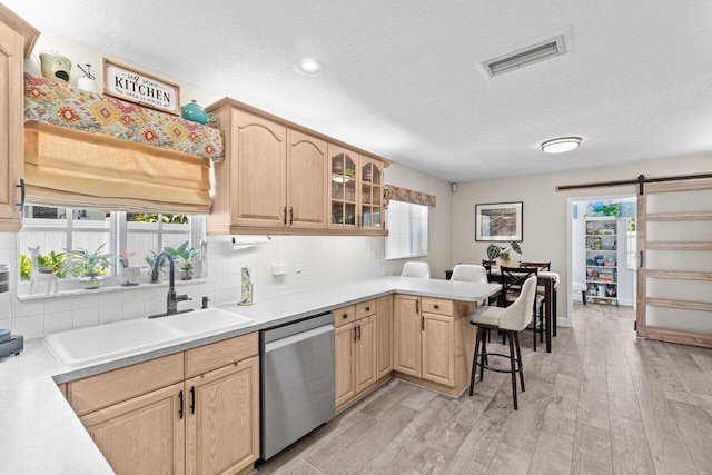 639 Mallard Dr, Delray Beach, FL 33444 - kitchen featuring stainless steel dishwasher, a sink, light brown cabinetry, a peninsula, and a textured ceiling