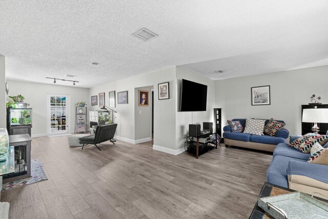 639 Mallard Dr, Delray Beach, FL 33444 - living room featuring light wood-type flooring, a textured ceiling, and baseboards