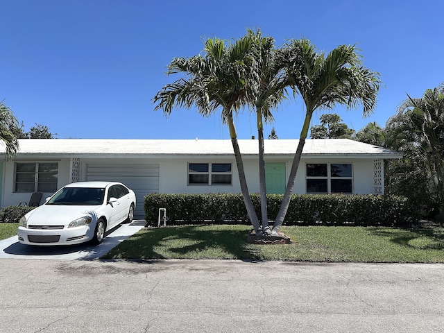 728 Ridge Rd Unit 35, Lantana, FL 33462 - ranch-style house with a garage, a front lawn, and stucco siding