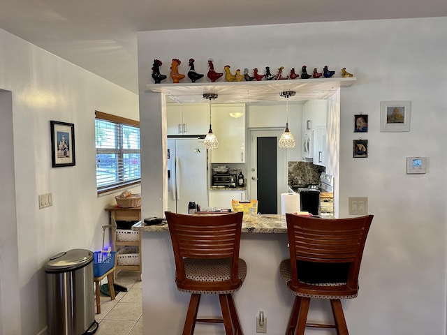 728 Ridge Rd Unit 35, Lantana, FL 33462 - bar area with white appliances, light tile patterned flooring, and hanging light fixtures