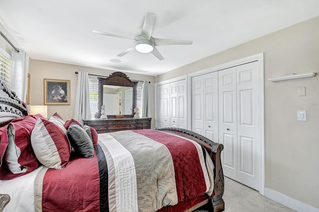 bedroom featuring two closets, baseboards, and ceiling fan