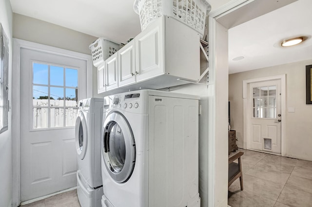 laundry room featuring separate washer and dryer, cabinet space, and light tile patterned floors