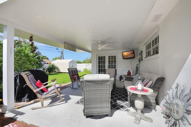 view of patio / terrace featuring french doors, a shed, an outdoor structure, ceiling fan, and fence