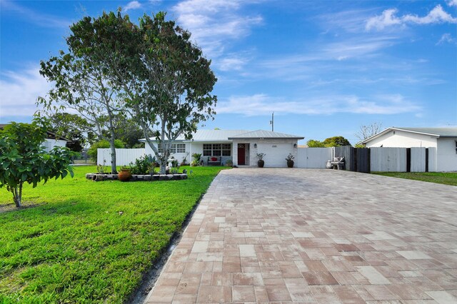 ranch-style home featuring decorative driveway and metal roof