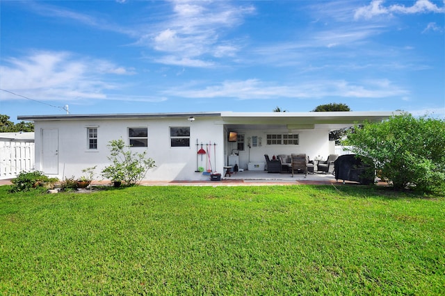 rear view of house with an outdoor living space, a yard, stucco siding, and a patio area