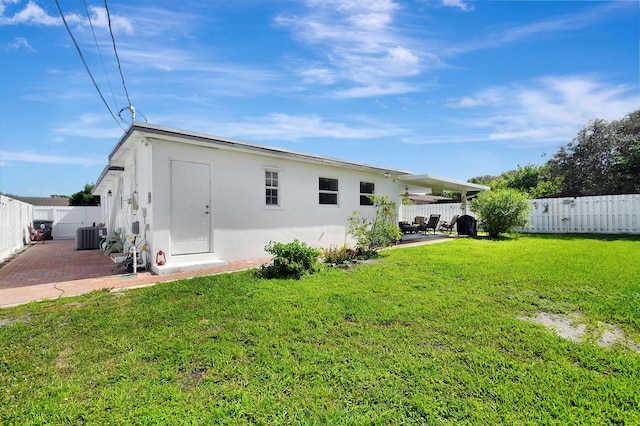 back of house with stucco siding, a patio area, central air condition unit, and an outbuilding