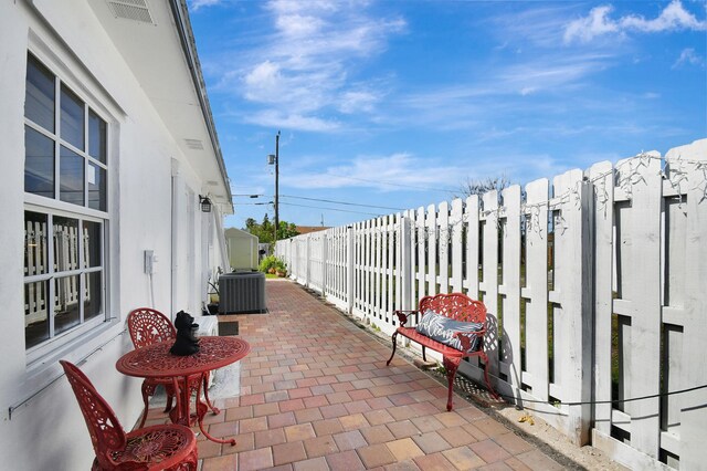 view of patio / terrace with central air condition unit and a fenced backyard