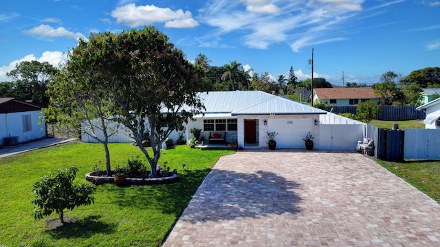 ranch-style house featuring driveway, a garage, and metal roof