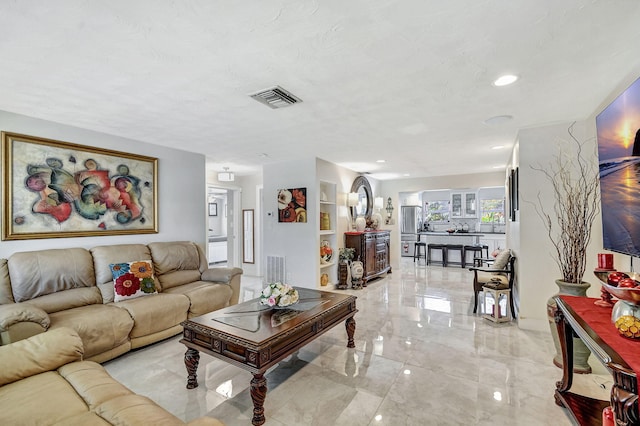 living area featuring light marble finish flooring and recessed lighting