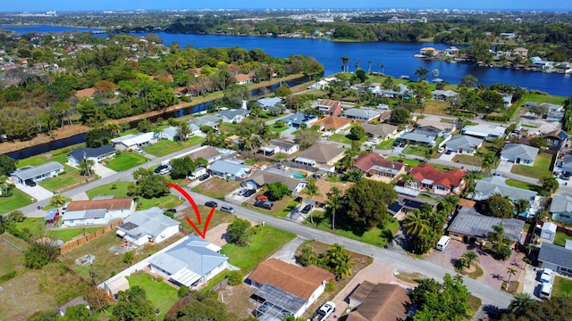 aerial view of property and surrounding area with a nearby body of water and nearby suburban area