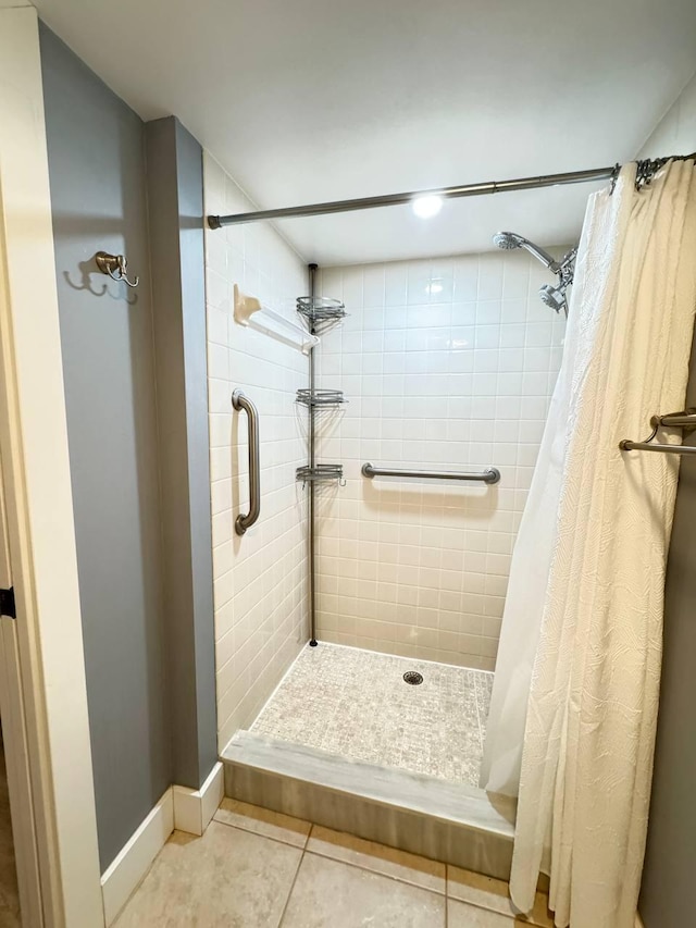 bathroom featuring a shower stall, tile patterned floors, and baseboards
