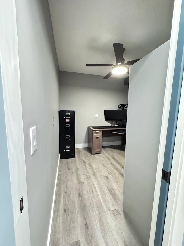 office area featuring ceiling fan, light wood-type flooring, and baseboards