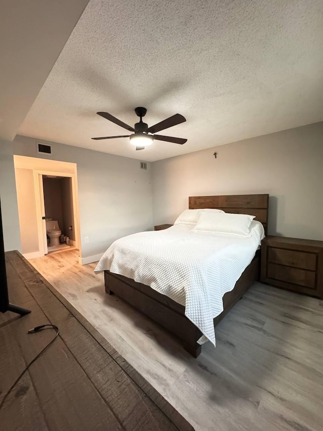 bedroom featuring wood finished floors, a textured ceiling, a ceiling fan, and baseboards