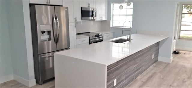14516 Canalview Dr Unit B, Delray Beach, FL 33484 - kitchen with stainless steel appliances, plenty of natural light, white cabinetry, and light countertops
