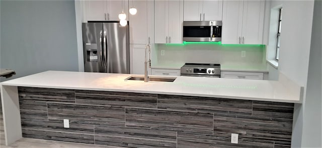 14516 Canalview Dr Unit B, Delray Beach, FL 33484 - kitchen with stainless steel appliances, white cabinets, light countertops, and pendant lighting