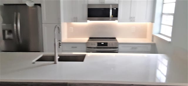 14516 Canalview Dr Unit B, Delray Beach, FL 33484 - kitchen featuring appliances with stainless steel finishes, light countertops, and white cabinets
