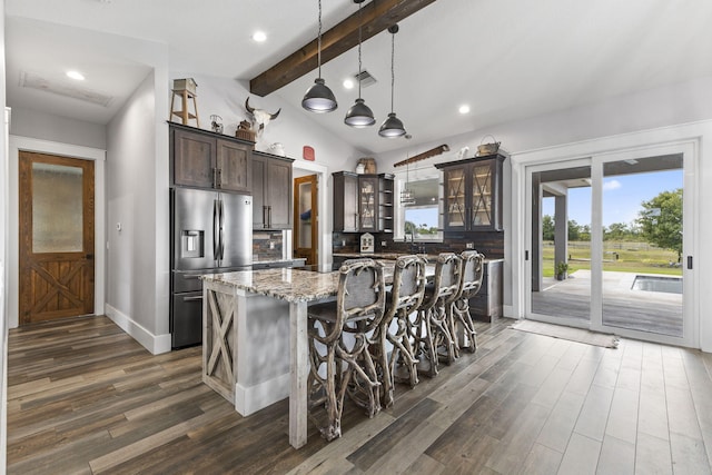 1545 Pulitzer Rd, Fort Pierce, FL 34945 - kitchen featuring stainless steel fridge, dark wood finished floors, dark brown cabinets, a kitchen island with sink, and light stone countertops