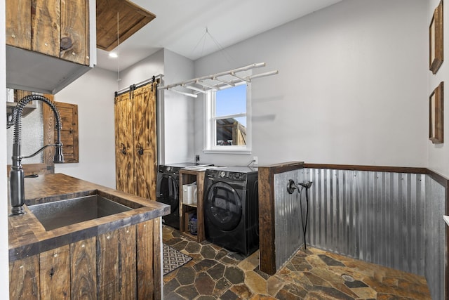 1545 Pulitzer Rd, Fort Pierce, FL 34945 - laundry room with washer and dryer, stone floors, a barn door, and cabinet space