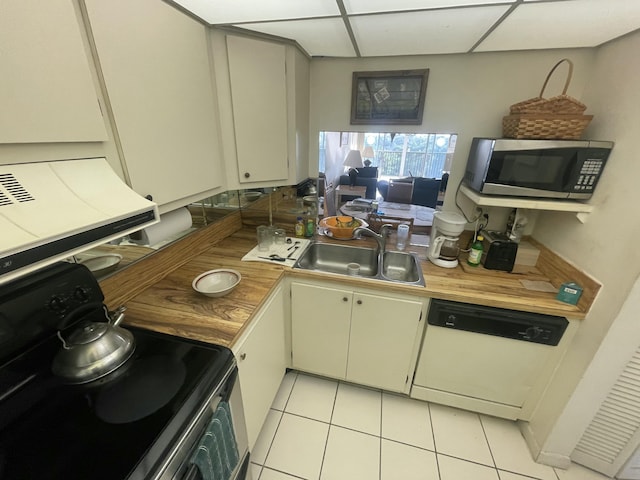 kitchen with electric range, stainless steel microwave, dishwasher, light tile patterned flooring, and a sink