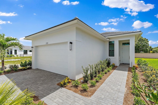 308 SE Via Sangro, Port Saint Lucie, FL 34987 - view of front of house with an attached garage, stucco siding, fence, and driveway