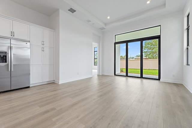 308 SE Via Sangro, Port Saint Lucie, FL 34987 - unfurnished living room with light wood finished floors, plenty of natural light, a raised ceiling, baseboards, and recessed lighting