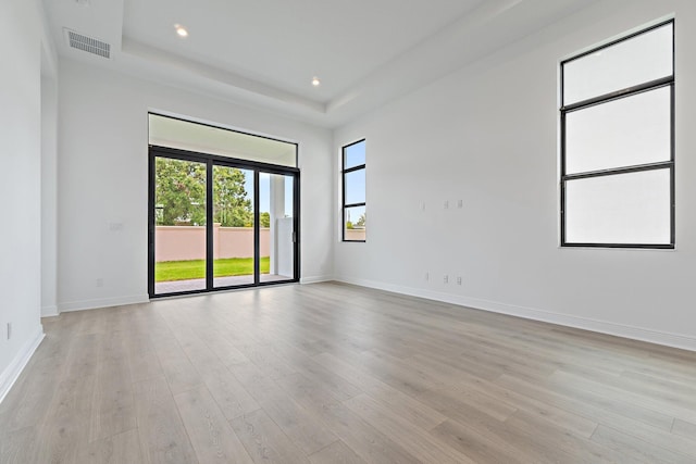 308 SE Via Sangro, Port Saint Lucie, FL 34987 - spare room featuring light wood-type flooring, baseboards, a raised ceiling, and recessed lighting