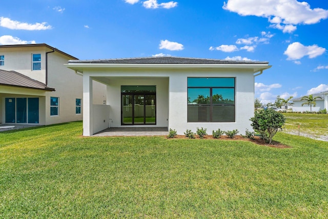 308 SE Via Sangro, Port Saint Lucie, FL 34987 - back of property with stucco siding, a yard, and a patio