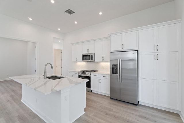 308 SE Via Sangro, Port Saint Lucie, FL 34987 - kitchen with stainless steel appliances, a sink, a kitchen island with sink, white cabinets, and recessed lighting
