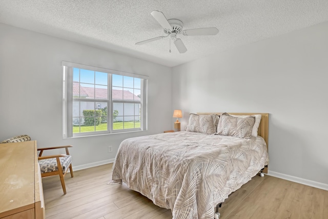 1265 Pine Sage Cir, West Palm Beach, FL 33409 - bedroom featuring light wood-type flooring, a textured ceiling, and ceiling fan