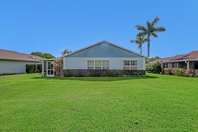 1265 Pine Sage Cir, West Palm Beach, FL 33409 - rear view of house with a lawn, a sunroom, and stucco siding