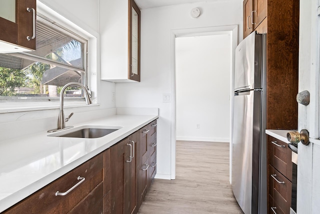 604 W Ocean Ave, Lantana, FL 33462 - kitchen with freestanding refrigerator, a sink, light wood finished floors, and light countertops