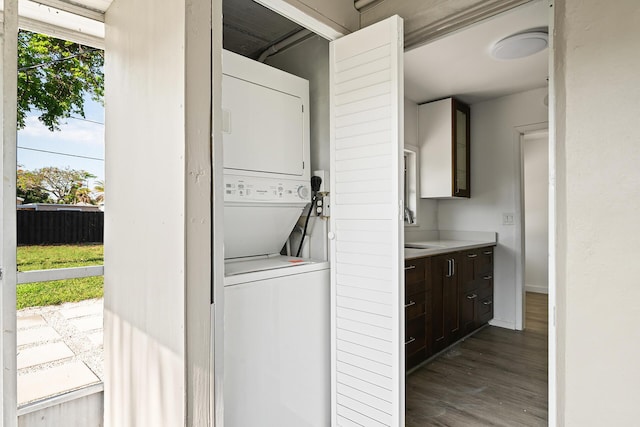 604 W Ocean Ave, Lantana, FL 33462 - laundry area with stacked washer and clothes dryer, plenty of natural light, dark wood-style flooring, and baseboards