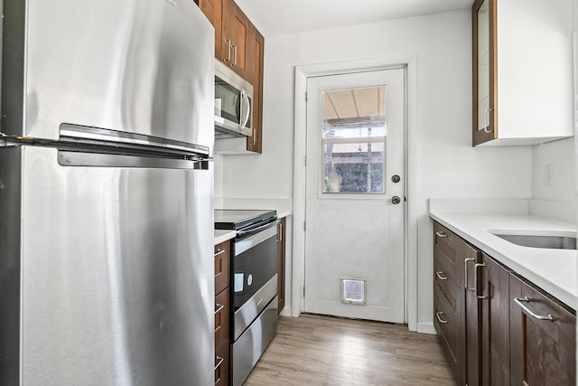 604 W Ocean Ave, Lantana, FL 33462 - kitchen with appliances with stainless steel finishes, light countertops, light wood-style flooring, and a sink