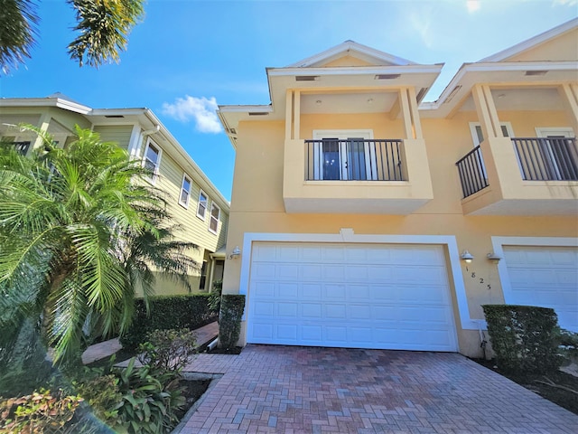 1825 Bridgepointe Cir Unit 15, Vero Beach, FL 32967 - view of front of home featuring stucco siding, a garage, a balcony, and decorative driveway