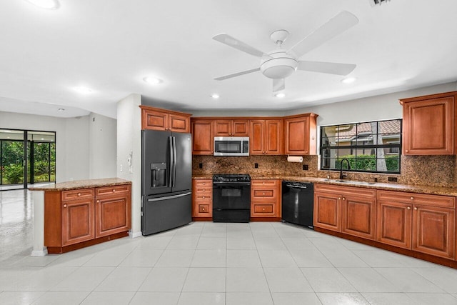 10535 Ladypalm Ln Unit B, Boca Raton, FL 33498 - kitchen featuring black appliances, a sink, backsplash, brown cabinetry, and dark stone countertops