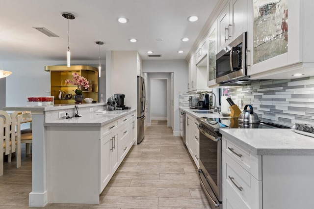 21188 Juego Cir Unit 17-A, Boca Raton, FL 33433 - kitchen featuring stainless steel appliances, a sink, backsplash, white cabinets, and recessed lighting