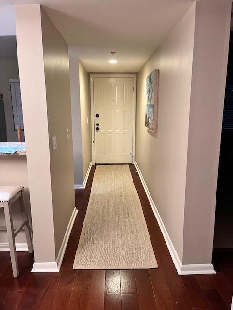doorway to outside with baseboards and wood-type flooring