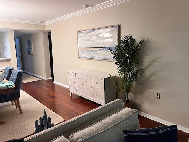 living room featuring ornamental molding, wood finished floors, and baseboards