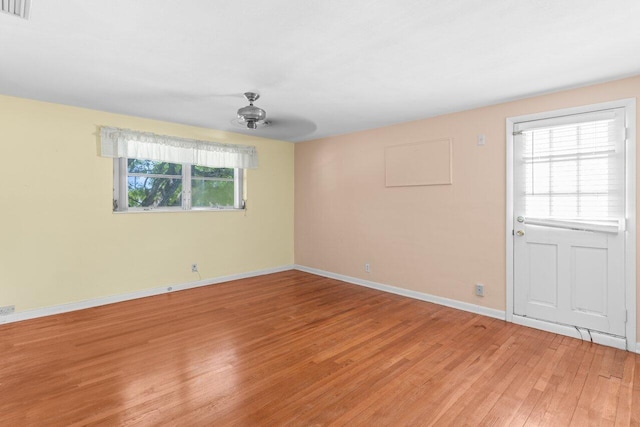 spare room featuring light wood-type flooring and baseboards