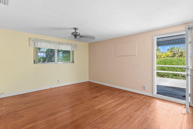 unfurnished room featuring light wood-style floors, healthy amount of natural light, baseboards, and a ceiling fan