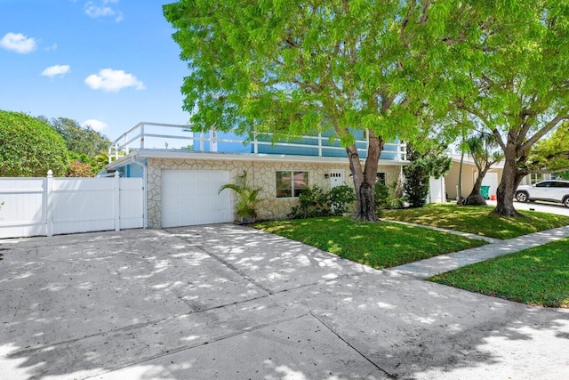 view of front facade with an attached garage, stone siding, and concrete driveway
