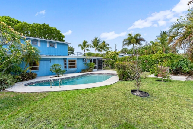 outdoor pool featuring a yard